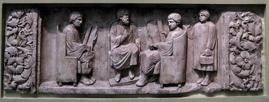 Roman School from the Neumagen Relief [ca. 180 C.E.], from Wikimedia Commons.

