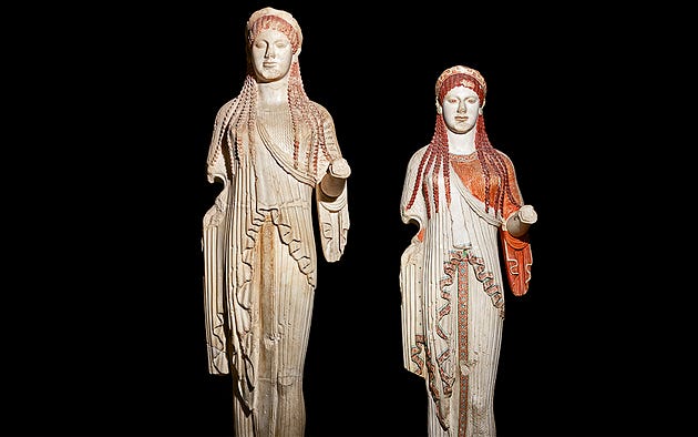  Kore 685: the original statue and a modern, painted replica, reproduced with a high degree of accuracy thanks to the efforts of the Swiss painter Émile Gilliéron a century ago. The coloring is based on archival watercolors, completed immediately after the statue’s discovery in 1888. © Nikos Pilos

