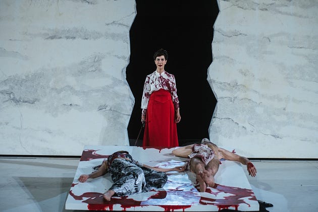  Clytemnestra (Anne Alvaro) stands behind the corpses of Cassandra (Astrid Bas) and Agamemnon (Carlo Brandt), L’Orestie d’Eschyle, directed by George Lavaudant, performed at the Roman theater of Fourviere. (photo by Paul Bourdel)